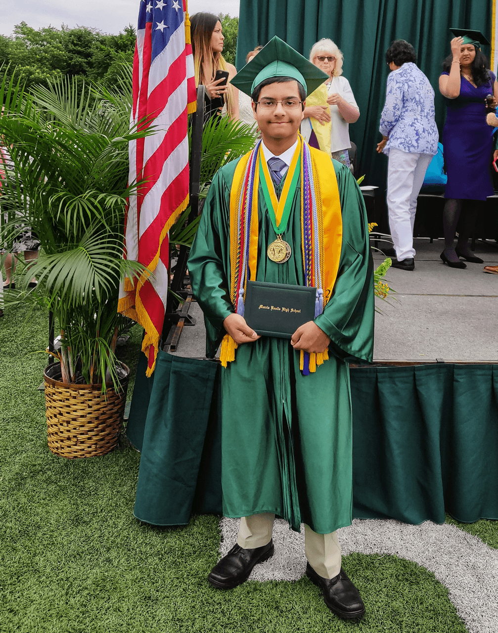 Sumantra Chattopadhyay wearing green graduation cap and gown with honor cords and medals for Morris Knolls High School graduation ceremony 2018